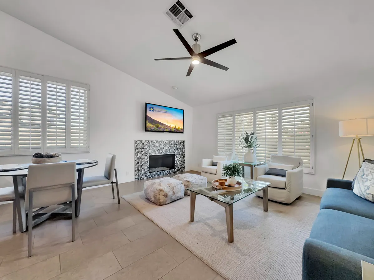 A warm and cozy interior with a glowing fireplace, a welcoming dining table, a comfortable sofa, and a coffee table—ideal for relaxing and hosting friends. The scene is perfect for post-golf relaxation and sharing stories around the fire.