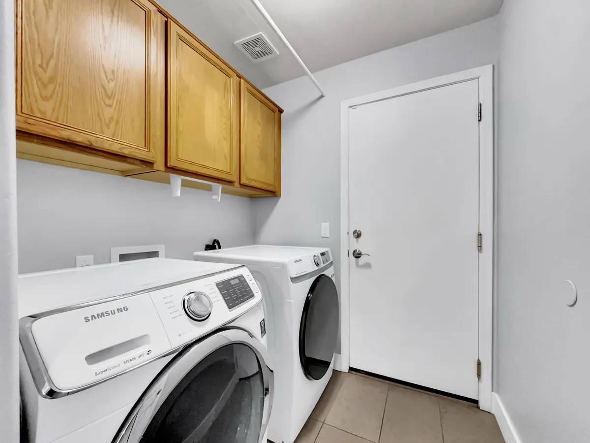 A functional laundry area equipped with a washer, dryer, and ample storage cabinets. The orderly, clean design makes extended stays and business travel more convenient, ensuring guests can easily handle daily routines.